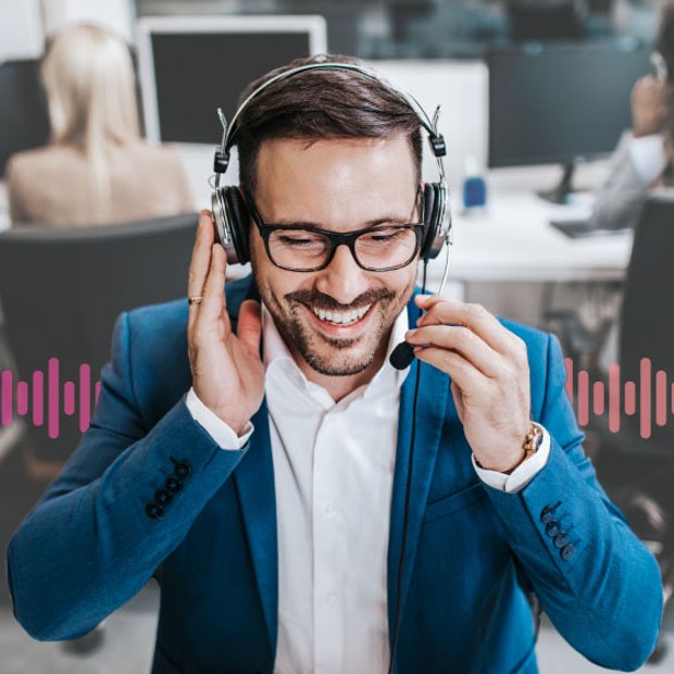Photo of a a smiling call center agent talking to a customer through his phone headset. In the background, a series of small vertical lines runs across the frame, representing communication.