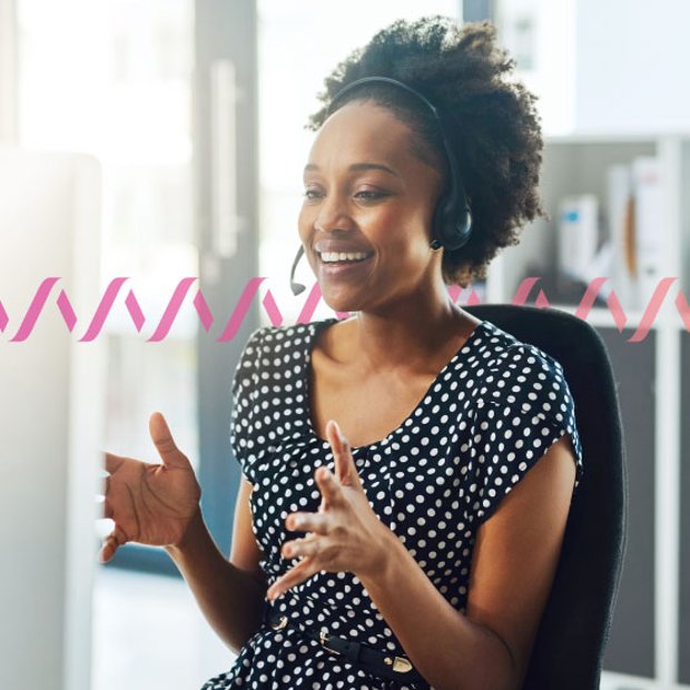 Photo of a smiling call center agent gesturing with her hands as she talks to a customer over her headset. In the background, a series of small "sound waves" run across the frame.