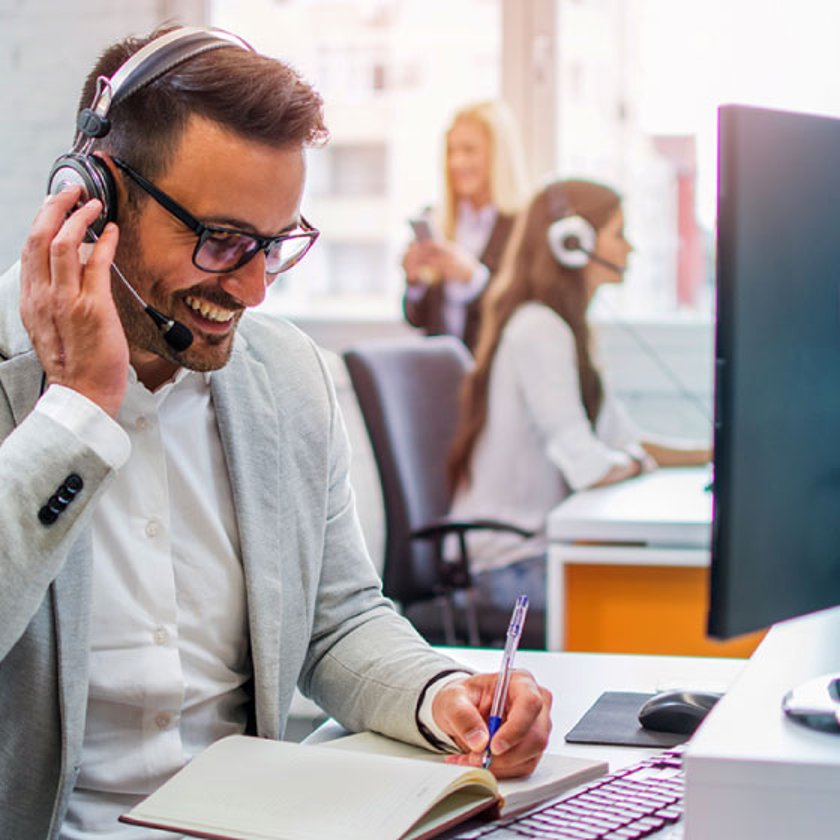 Photo of a smiling call center agent on the phone with a customer
