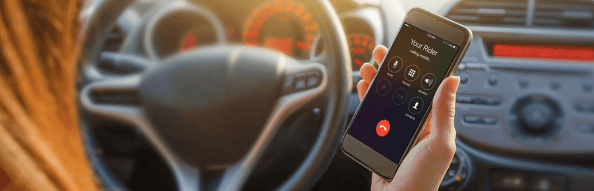 Person inside car holding phone with Grab app open